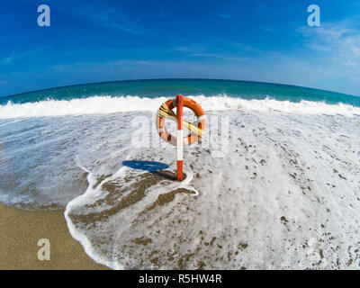 Die Wellen erreichen den Rettungsring in der Mitte des Strandes Stockfoto