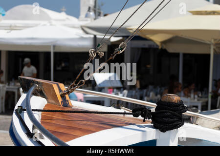 Deck von einem Segelboot mit Linien, Strand Restaurant im Hintergrund, an einem sonnigen Tag auf der Insel Paros, Griechenland, Stockfoto