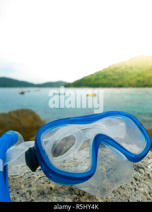 Schnorcheln: Schnorcheln und Tauchen Google auf dem Stein. Tropische Insel, Meer, Strand und Boote im Hintergrund. Stockfoto