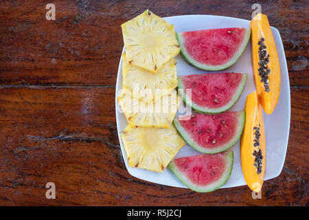 In Scheiben geschnittene Früchte auf weiße Platte wurde am Tisch serviert. Stockfoto