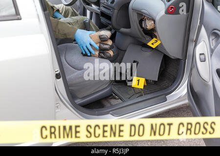 Polizeioffizier holding Droge Pakete im Geheimfach eines Autos gefunden Stockfoto