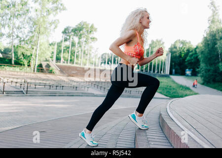 Foto des lockigen Haaren athletische Frau durch den Park zu laufen Stockfoto