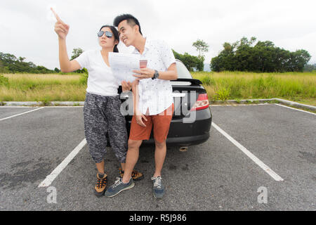 Paar nach einer Autopanne an der Seite der Straße Stockfoto