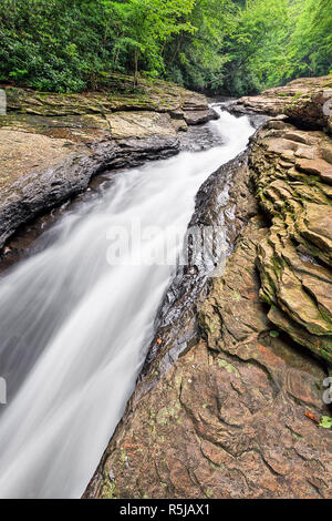 Wildwasser fließt durch Wiese laufen hat einen schmalen Kanal in den Felsen, als entspannende Wasserrutsche in der Pennsylvania Laurel verwendet wird geschnitzt Stockfoto