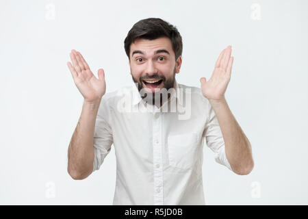 Kompromisslos glücklich und aufgeregt, jungen gutaussehenden Mann die Hände in der Freude. Stockfoto