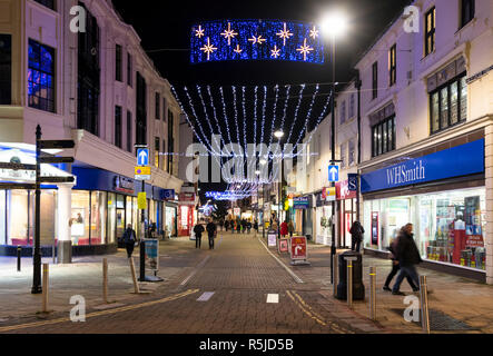 Weihnachtsbeleuchtung und Dekoration in der Nacht im Freien Einkaufsmöglichkeiten in Montague Street in Worthing, West Sussex, England, UK. Stockfoto