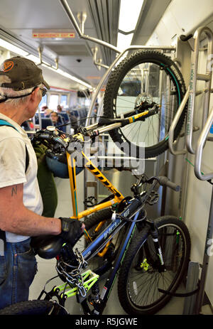 Mann Transport sein Fahrrad im Zug in Denver, Colorado, USA. Fahrradträger Stockfoto