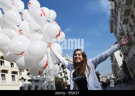 Thessaloniki, Griechenland. 1. Dez, 2018. Ein Mädchen hält Luftballons mit dem Red Ribbon Symbol auf Ihnen. Das Griechische Zentrum für die Prävention und die Kontrolle von Krankheiten organisiert eine informative Veranstaltung zum Welt-AIDS-Tag 2018, um das Bewusstsein für die AIDS-Pandemie durch die Ausbreitung der HIV-Infektion zu erhöhen. Credit: Giannis Papanikos/ZUMA Draht/Alamy leben Nachrichten Stockfoto