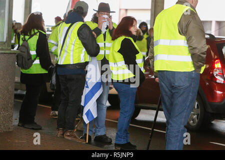 Lauterbourg, Frankreich. 1. Dezember 2018. Eine Demonstrantin trägt eine israelische Flagge. Rund 100 Französische gelbe Weste Aktivisten protestierten am Französischen deutschen Grenzübergang bei Lauterbourg gegen die französische Regierung und die Erhöhung der Mineralölsteuer. Sie wurden von rund 30 Aktivisten der Deutschen rechten Frauen Bündnis Kandel unterstützt. Sie waren Teil der grösseren gelbe Weste Protestbewegung in Frankreich. Quelle: Michael Debets/Alamy leben Nachrichten Stockfoto