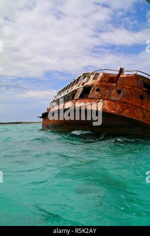 Verrosteten Schiffswrack auf die Seite im flachen Wasser der Karibik durch einen Hurrikan zerstört Stockfoto