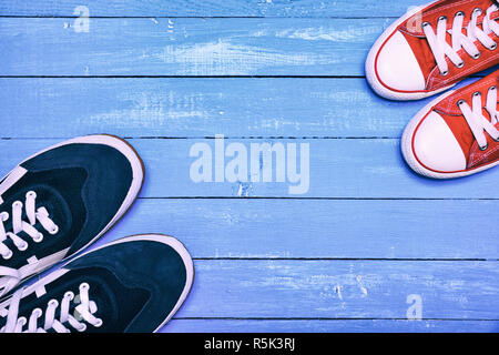 Zwei Paare von sportlichen Sneakers, die blauen Männer Sneakers und roten Frauen Stockfoto