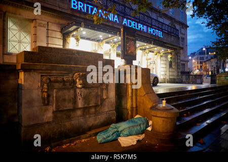 Das Stadtzentrum von Liverpool einen Obdachlosen schlafen in einem Schlafsack wieder auf den Bürgersteig außerhalb iconic Britannia Adelphi Hotel Schritte Stockfoto