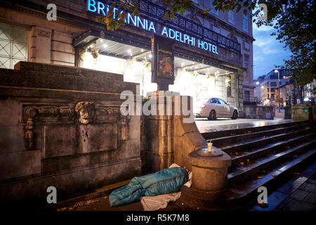 Das Stadtzentrum von Liverpool einen Obdachlosen schlafen in einem Schlafsack wieder auf den Bürgersteig außerhalb iconic Britannia Adelphi Hotel Schritte Stockfoto
