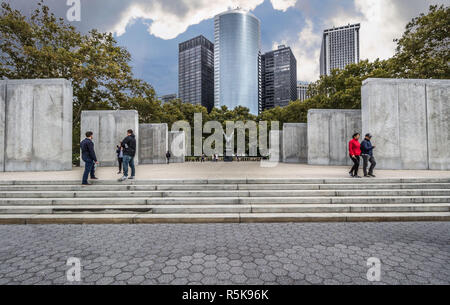 Ostküste War Memorial, Battery Park, Manhattan, New York, USA. 14. Oktober 2018. Eine breite Aufnahme der Steine des Gedenkens und der Statue mit Touristen suchen, Stockfoto