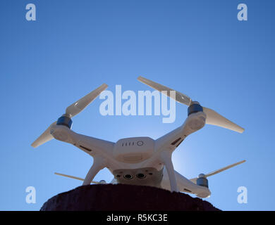 Quadrocopter Phantom 4 gegen den blauen Himmel in der Sonne. Hintergrundbeleuchtung. Dron ist ein innovatives fliegenden Roboter. Stockfoto