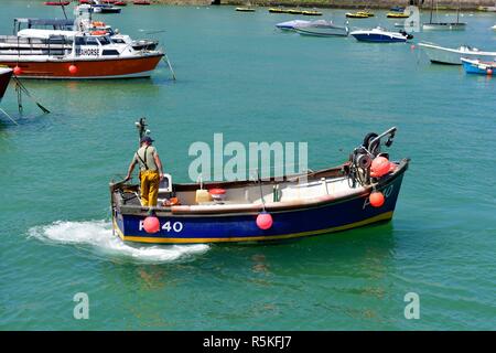 Fischer auf einem kleinen Fischerboot im Hafen von St Ives, Cornwall, England, Großbritannien Stockfoto