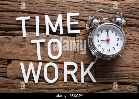 Zeit zu arbeiten Text von Wecker Stockfoto