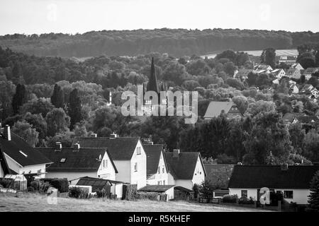 Blick auf die kleine Stadt Neustadt (Landkreis Marburg-Biedenkopf in Hessen), einem Vorort und die umliegenden landwirtschaftlichen Flächen. Schwarz und Weiß. Stockfoto