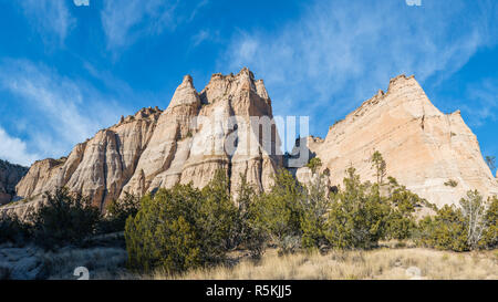 Panorama von steilen, scharfen Spitzen und Felsformationen über einer Wiese Wiese unter einem blauen Himmel mit dünnen Wolken bei Kasha-Katuwe Tent Rocks National Monumen Stockfoto