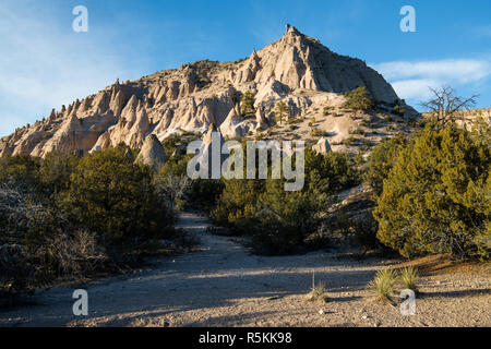 Eine hohe, steile Wüste Peak mit ungewöhnlichen Türme und Felsformationen im Licht des Sonnenuntergangs an Kasha-Katuwe Tent Rocks National Monument, New Mexico Stockfoto