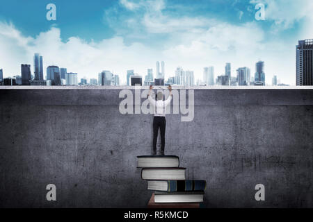 Asian Business mann Buch klettern Stockfoto