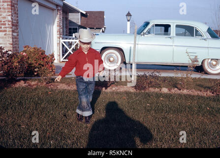 Vier Jahre alten Jungen stellt in seinem Vorgarten, 1958, USA Stockfoto