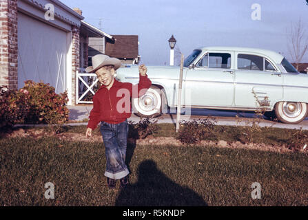 Vier Jahre alten Jungen stellt in seinem Vorgarten, 1958, USA Stockfoto