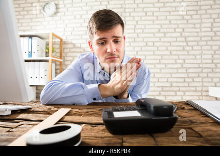 Unternehmer Warten auf Anruf auf Telefon Stockfoto