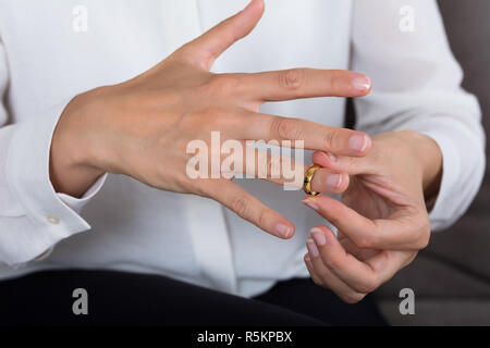 Frau Setzen auf ein glänzendes Gold Ring Stockfoto