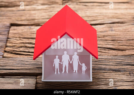 Papier Familie in Haus Modell auf Tisch Stockfoto