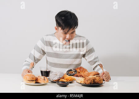 Junger Mann zu Hause auf eine ungesunde Ernährung Stockfoto