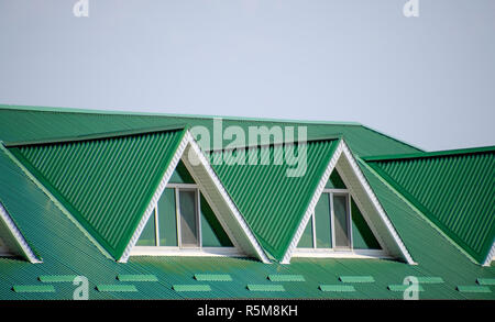 Das Haus mit Kunststoff Fenstern und einem grünen Dach aus Wellblech. Das grüne Dach Wellblech Profil und Kunststoff Fenster. Stockfoto