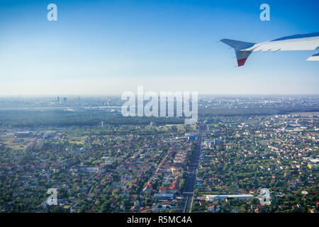 Weg vom Flughafen Otopeni; Fliegen über Wohngebiete, Bukarest Skyline im Hintergrund ; Rumänien Stockfoto