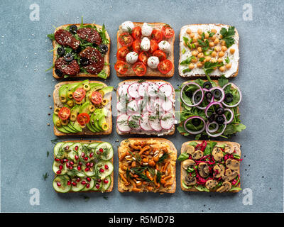 Sortiment veganen Sandwiches auf grauem Stein Hintergrund. Verschiedene vegetarische smorrebrod. Top View oder flach. Stockfoto