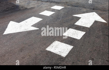 Verkehrsschild weiße Pfeile auf Asphalt Stockfoto