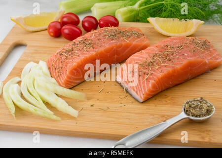 Lachs und Gemüse auf einem Schneidebrett Stockfoto