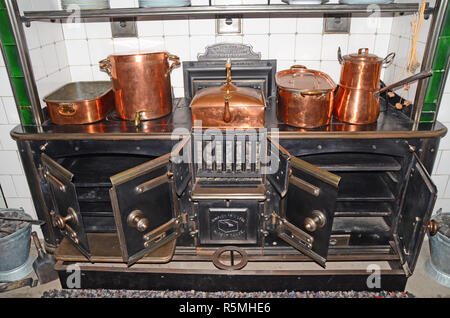 Große. Antike/vintage Küche Herd mit einer Vielzahl von Kupfer Pfannen und Töpfe. Stockfoto