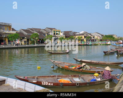 HOI AN (Hoi An), Vietnam - 19. MÄRZ 2018: Besetzt Fluss in Hoi An Altstadt mit Blick auf die traditionellen Boote, gelbe Häuser und Touristen Stockfoto