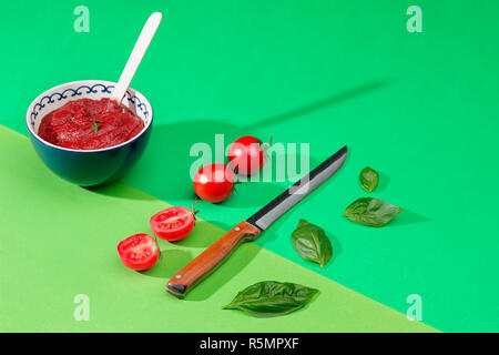 Schüssel mit gehackten Tomaten am grünen Tisch Stockfoto