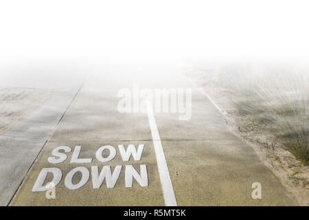 Verlangsamen Sie Zeichen auf gemeinsam genutzten Gehweg für Radfahrer und Fußgänger verschwinden unter niedrige Wolken und Nebel geschrieben Stockfoto