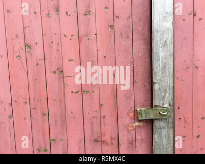 Holzlatten von eine alte Tür mit rosa Malerei Stockfoto