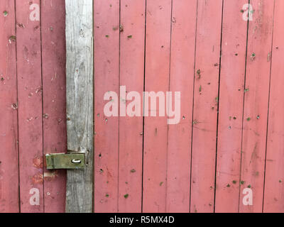 Holzlatten von eine alte Tür mit rosa Malerei Stockfoto