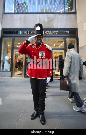 Ein Pförtner gekleidet wie ein Spielzeug Soldat steht außerhalb der FAO Schwarz neu eröffnet Flagship Store am Rockefeller Plaza in Midtown Manhattan Stockfoto