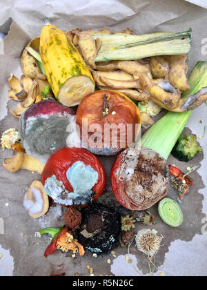 Schimmeliges Obst und Gemüse auf grauem Papier in Nahaufnahme Stockfoto