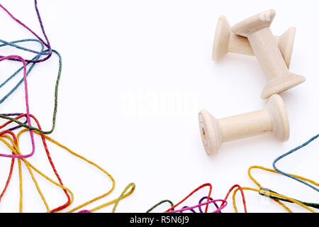 Bunte Fäden und hölzernen Schieber auf weißem Hintergrund Stockfoto