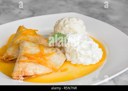 Crepes Suzette: Französisch dünne Pfannkuchen mit Orangensauce und Eis Stockfoto