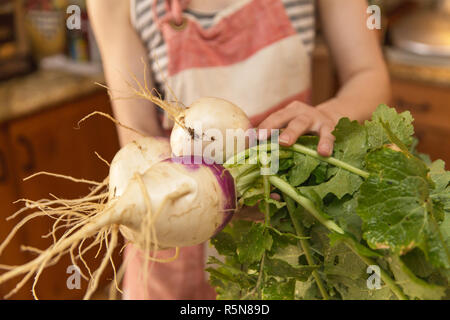 Frau im Vorfeld große, gesunde Rüben gezogen von einem Haus Garten. Stockfoto