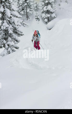 Frau Skifahrer, Freerider skitur bergauf im Schnee im Winter Wald Stockfoto