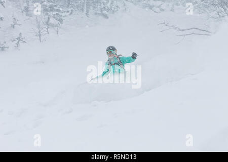 Frau Snowboarder, Freerider geht auf Pulverschnee in den Bergen in einem Schneefall Stockfoto