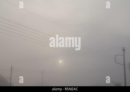 Elektrische Netzkabel Pylone bei Nebel und Sonne Stockfoto